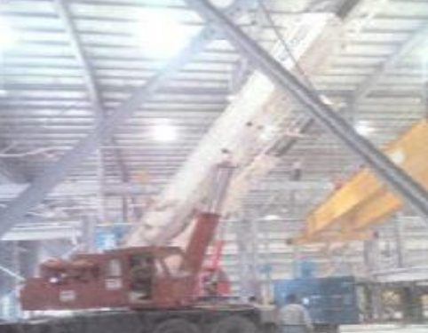 Mobile crane installing an overhead crane inside a hangar